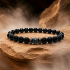 Black Obsidian labradorite crystal bracelet showcased on a natural stone platform with dramatic mist highlighting handcrafted gemstone jewelry.