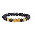 Black Obsidian Pixiu bracelet with glossy black beads and a gold Pixiu charm on white background