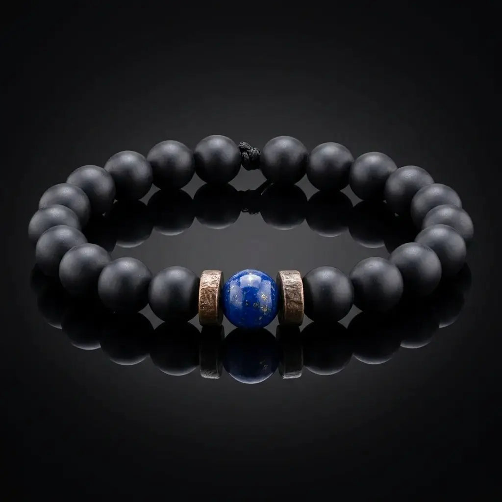 Black onyx and lapis lazuli bracelet on black reflective surface with dramatic studio lighting, luxury men's gemstone bracelet dark aesthetic