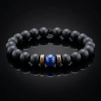 Black onyx and lapis lazuli bracelet on black reflective surface with dramatic studio lighting, luxury men's gemstone bracelet dark aesthetic