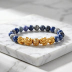 Blue tiger eye bracelet with blue gray beads, gold Pixiu dragon charms, and marble slab for premium wealth style