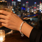 Cancer bracelet worn during an elegant city night out featuring gemstone beads and silver zodiac charm for stylish astrology jewelry