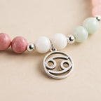 Cancer bracelet macro image showcasing silver Cancer zodiac charm with gemstone bead bracelet for astrology lovers