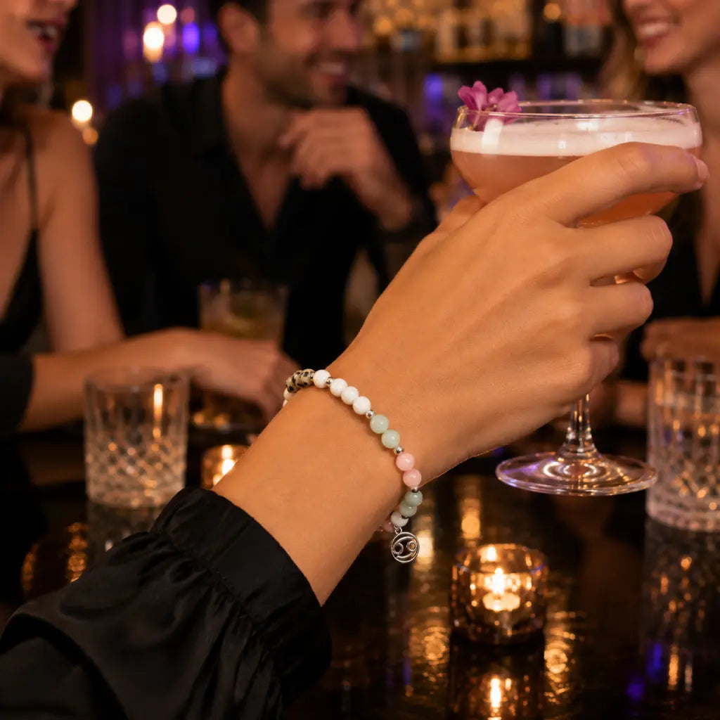 Cancer bracelet styled at social gathering with pastel gemstones silver accents and zodiac inspired charm design