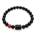 Cancer zodiac bracelet worn by man outdoors with black beads and red stone charm symbolizing strength and personal style energy