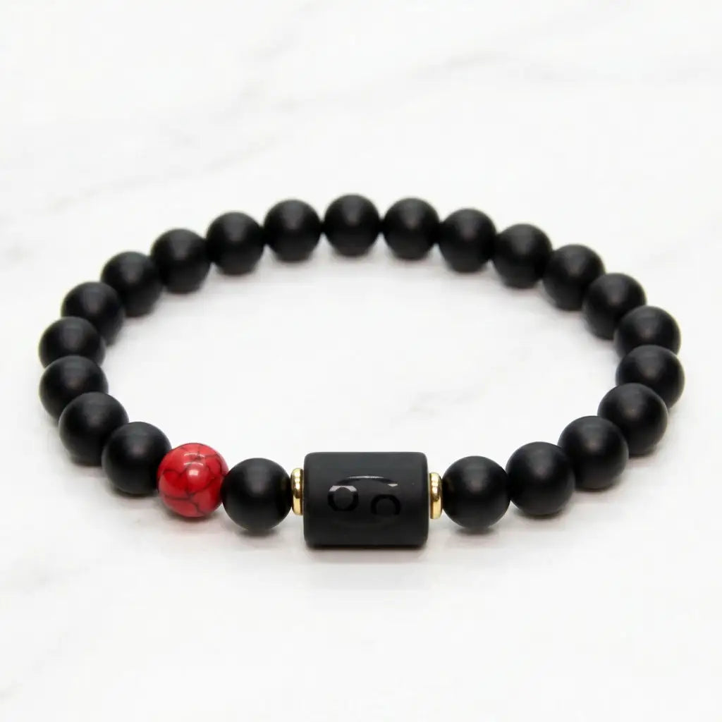 Cancer zodiac bracelet black beaded design on green velvet with red stone accent perfect for luxury gift and elegant presentation