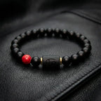 Cancer zodiac bracelet black beads with red stone on leather surface delivering masculine luxury style and bold everyday accessory appeal