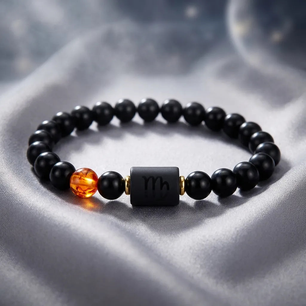 Capricorn zodiac bracelet on soft silver fabric with black beads and amber accent, offering elegant astrology jewelry styling