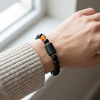 Capricorn zodiac bracelet styled with knit sleeve and amber bead, creating a cozy everyday fashion statement