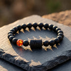 Capricorn zodiac bracelet displayed on stone surface with black beads and amber charm, emphasizing natural rugged style appeal