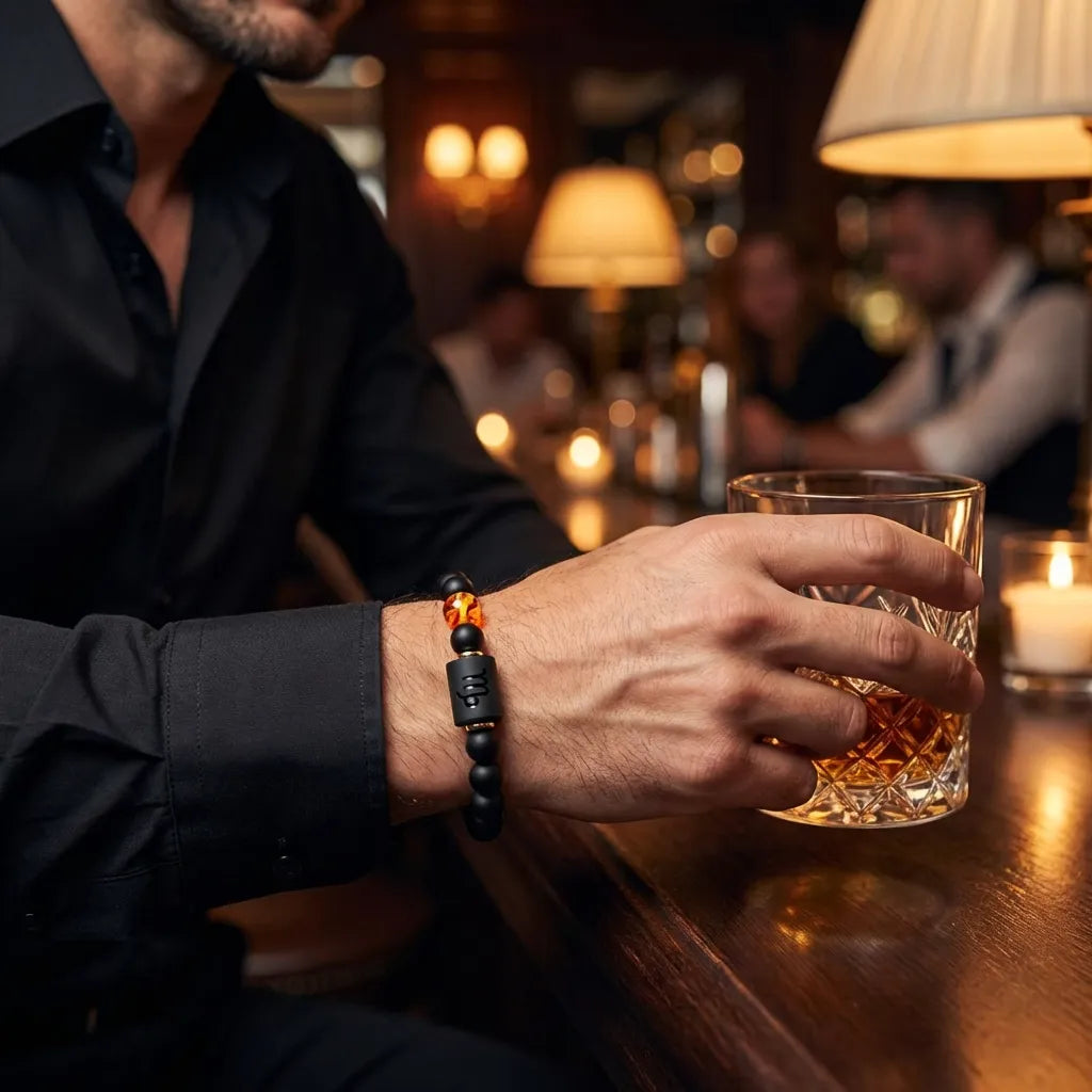 Capricorn zodiac bracelet worn at bar with black beads and amber charm, adding bold confident style for evening outings