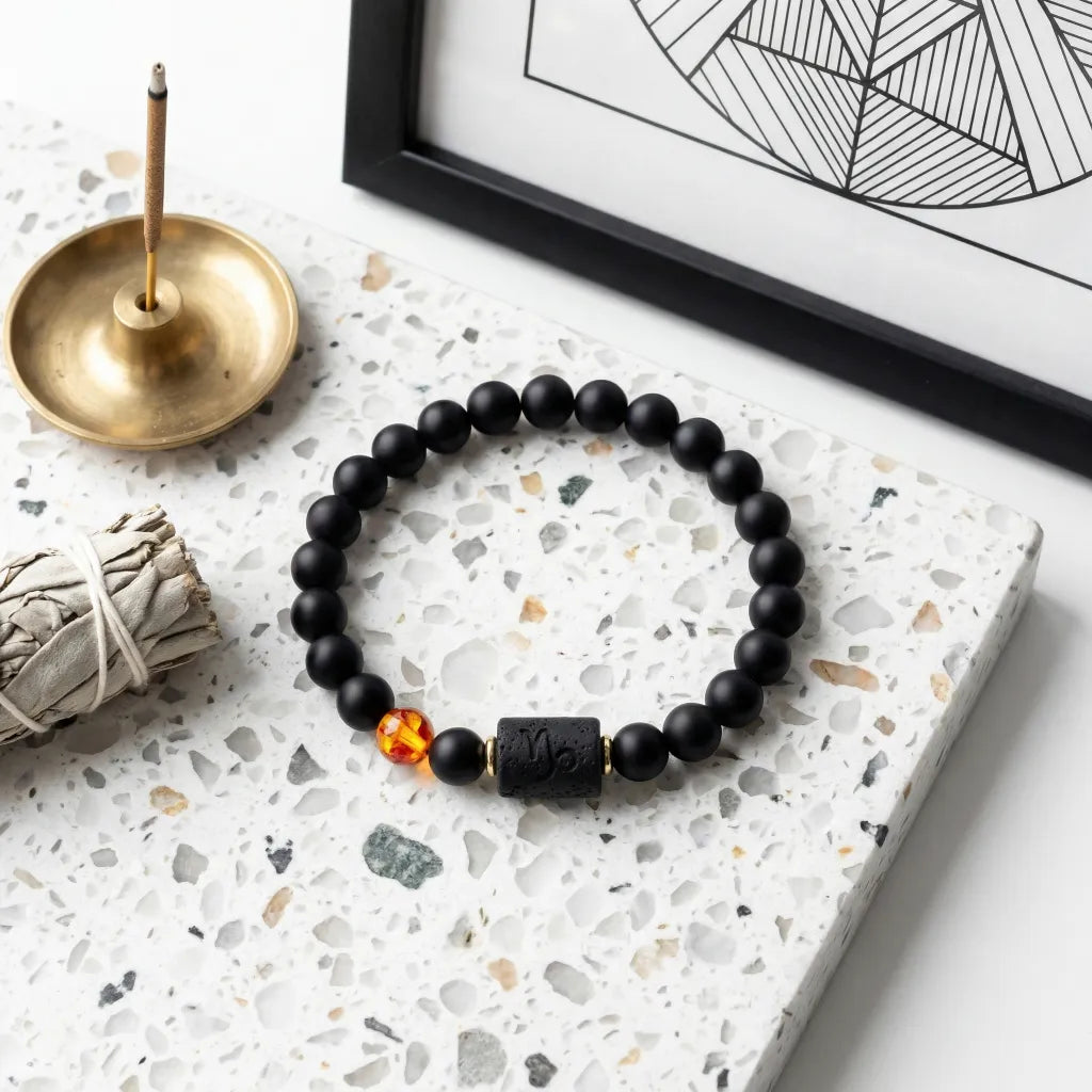 Capricorn zodiac bracelet displayed with incense and decor, black beads and amber detail create calming spiritual aesthetic