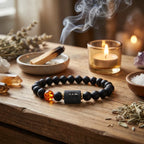 Capricorn zodiac bracelet on wooden table with candle and incense, black beads and amber charm create relaxing wellness ritual vibe