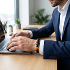 Capricorn zodiac bracelet worn with suit while working, featuring black beads and amber charm for confident professional style