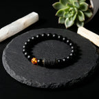 Capricorn zodiac bracelet on black stone with beads and amber charm, showcasing minimalist natural jewelry appeal