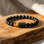 Capricorn zodiac bracelet on wooden surface with black beads and amber accent, highlighting handcrafted premium jewelry feel