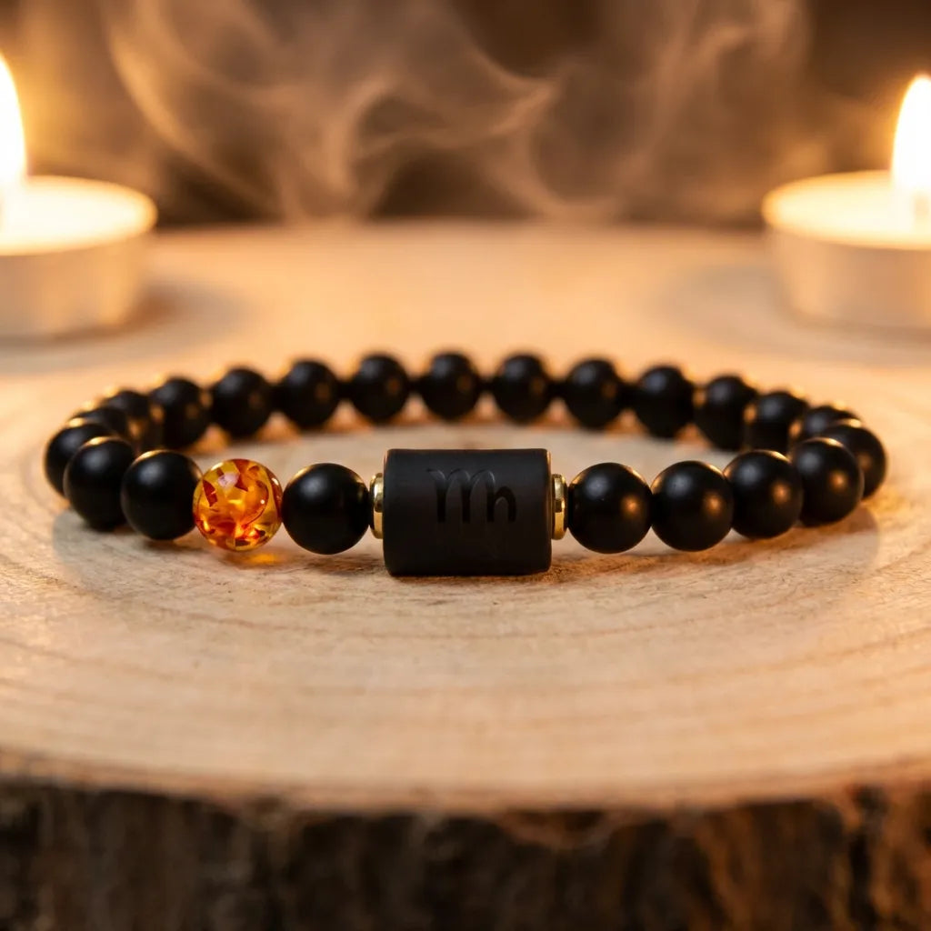 Capricorn zodiac bracelet with black beads and amber charm near candles and smoke, enhancing calming spiritual ritual energy