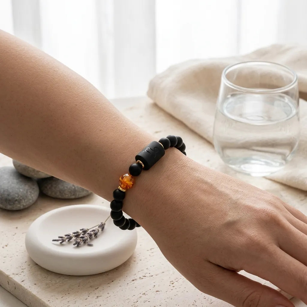 Capricorn zodiac bracelet beside spa elements with black beads and amber detail, promoting calm and mindful self-care ritual