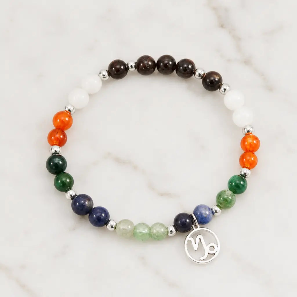 Capricorn zodiac crystal bracelet showcased on marble background with natural gemstones for premium jewelry presentation.