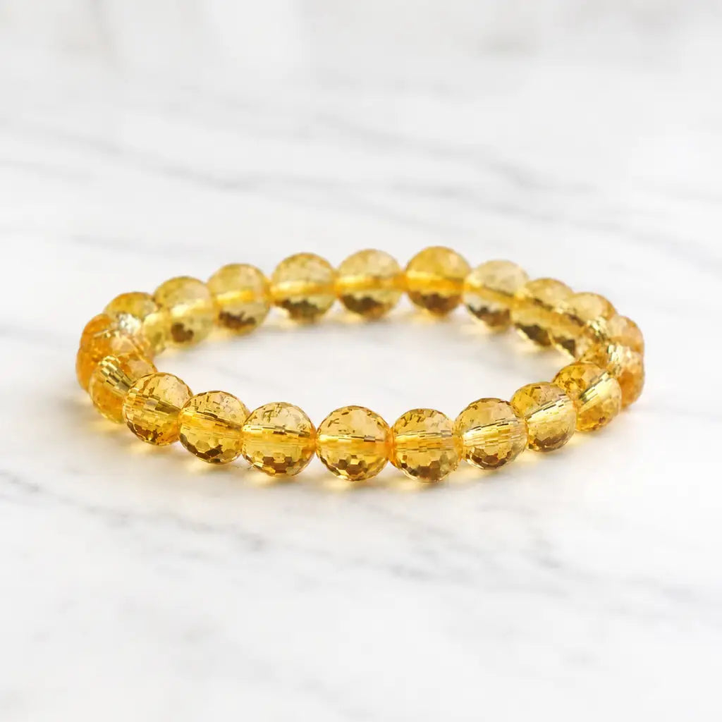 Citrine jewelry displayed on marble surface with faceted crystal bracelet for sophisticated beauty