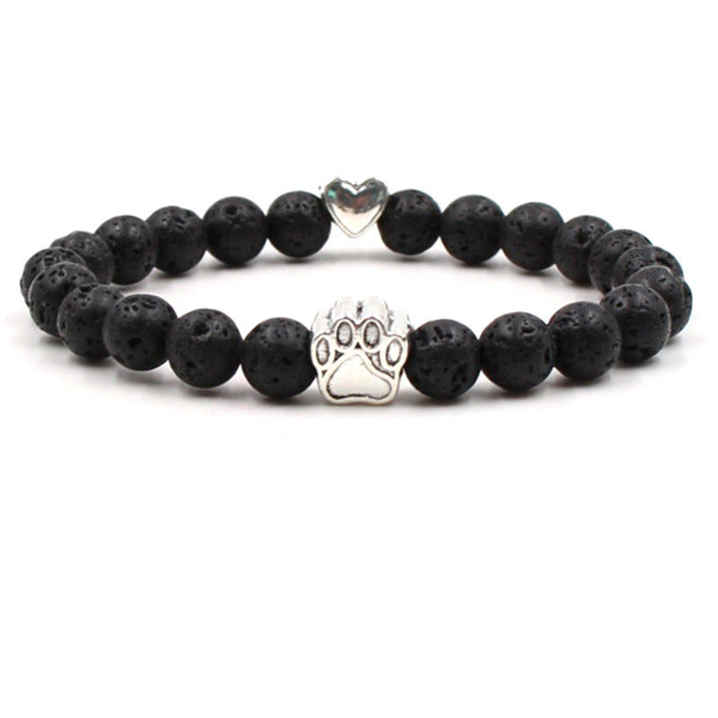 Dog paw stone bracelet with black textured beads, showing 8 mm round beads, a silver-color paw-print charm, a heart accent, and a circular unisex design on a bright white backdrop.