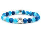 Dog paw stone bracelet with blue striped beads, showing 8 mm round beads, a silver-color paw-print charm, a heart accent, and a circular unisex design on a bright white background.
