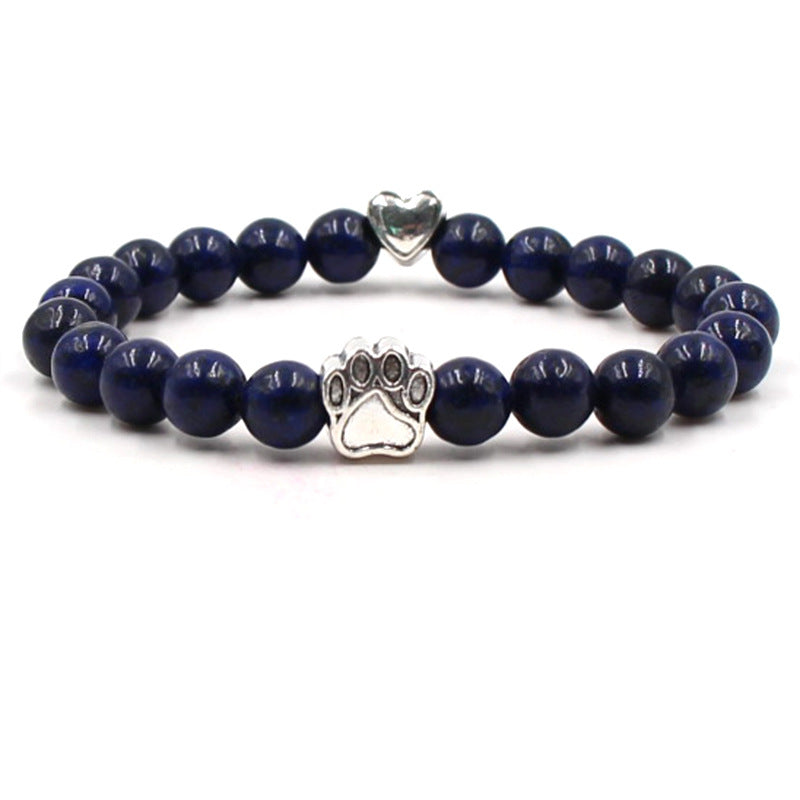 Dog paw stone bracelet with deep-blue beads, showing 8 mm round beads, a silver-color paw-print charm, a heart accent, and a circular unisex design on a clean white studio setting.