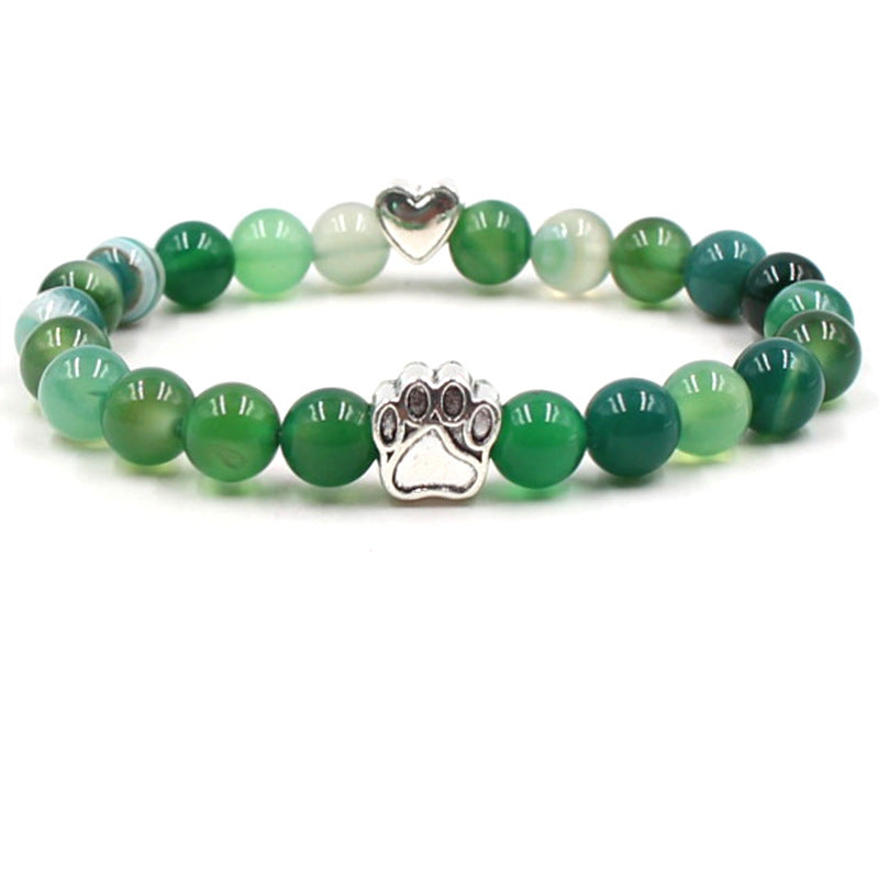Dog paw stone bracelet with green multitone beads, showing 8 mm round beads, a silver-color paw-print charm, a heart accent, and a circular unisex design on a clean white backdrop.