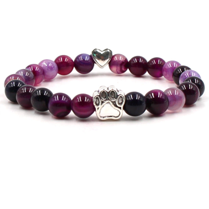 Dog paw stone bracelet with purple striped beads, showing 8 mm round beads, a silver-color paw-print charm, a heart accent, and a circular unisex design on a bright white backdrop.