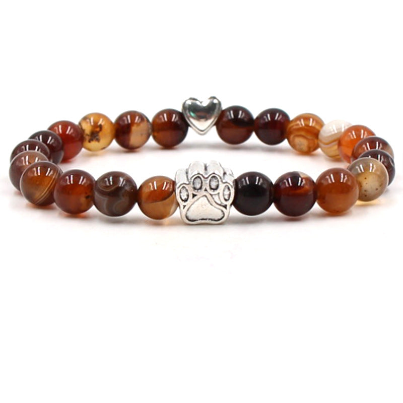 Dog paw stone bracelet with red-brown beads, showing 8 mm round beads, a silver-color paw-print charm, a heart accent, and a circular unisex design on a clean white studio setting.