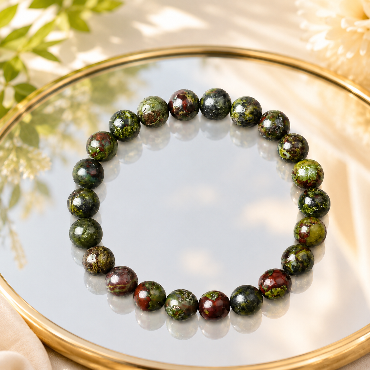 Dragon blood stone bracelet on round mirror tray with dried flowers, boho healing crystal stretch bracelet