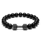 Dumbbell bracelet with matte black agate beads and a gun-black FIT LIFT centerpiece, shown in a neat front-facing circle on white for a clear view of the monochrome elastic design.
