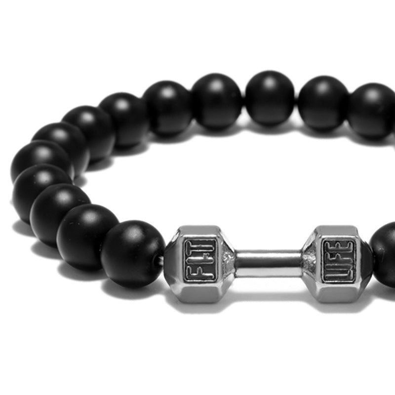 Dumbbell bracelet close-up showing matte black agate beads around a silver-tone FIT LIFT dumbbell centerpiece, with the polished bar and engraved ends all clearly visible on white.