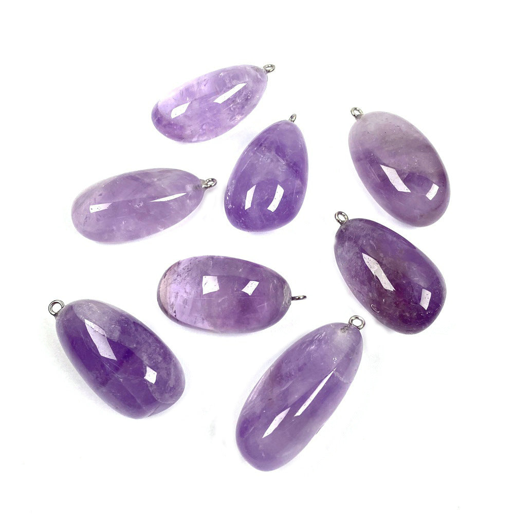 Freeform amethyst pendant group with polished purple pebble shapes, varied violet tones and sizes, visible inclusions, and silver-color hanging loops all displayed neatly on white.