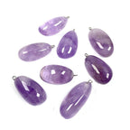 Freeform amethyst pendant group with polished purple pebble shapes, varied violet tones and sizes, visible inclusions, and silver-color hanging loops all displayed neatly on white.