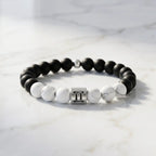Gemini bracelet on clean marble with matte onyx, white howlite, and silver twins charm for minimalist modern style