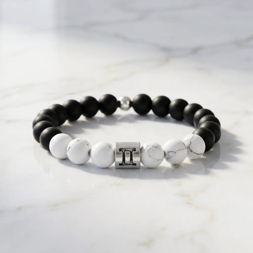 Gemini bracelet on clean marble with matte onyx, white howlite, and silver twins charm for minimalist modern style