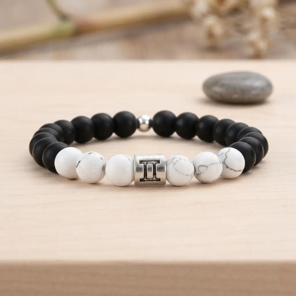 Gemini bracelet on wood display with black onyx, white howlite, and silver twins charm for thoughtful zodiac gift