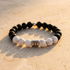 Gemini bracelet on warm stone with black onyx, white howlite, and silver zodiac charm for versatile daily style
