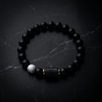 Gemini Zodiac Bracelet on dark marble background with matte beads, luxury astrology jewelry designed for bold style and energy balance