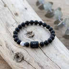 Gemini Zodiac Bracelet on rustic wood surface with black beads and white accent, natural astrology jewelry for grounded and stylish look