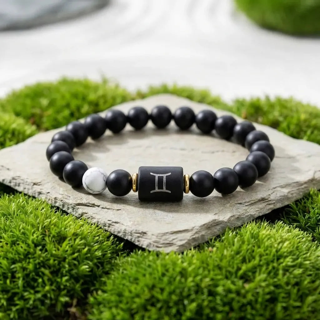 Gemini Zodiac Bracelet on stone with green grass background, black bead astrology jewelry for fresh outdoor style and everyday wear
