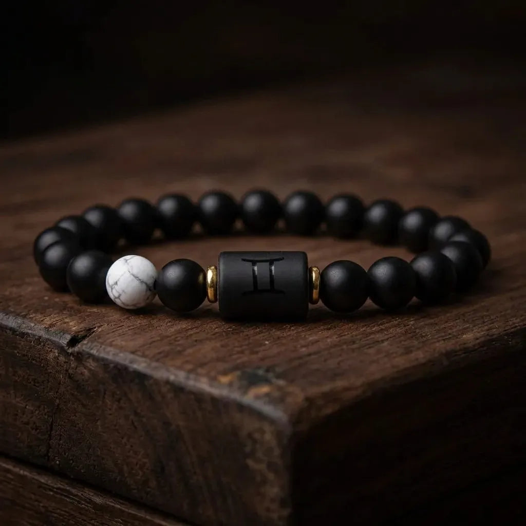 Gemini Zodiac Bracelet on rustic wood surface with black beads and white accent, handcrafted astrology jewelry for unique style expression