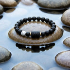 Gemini Zodiac Bracelet on stone with water reflection, black bead astrology jewelry for calm energy balance and mindful lifestyle appeal