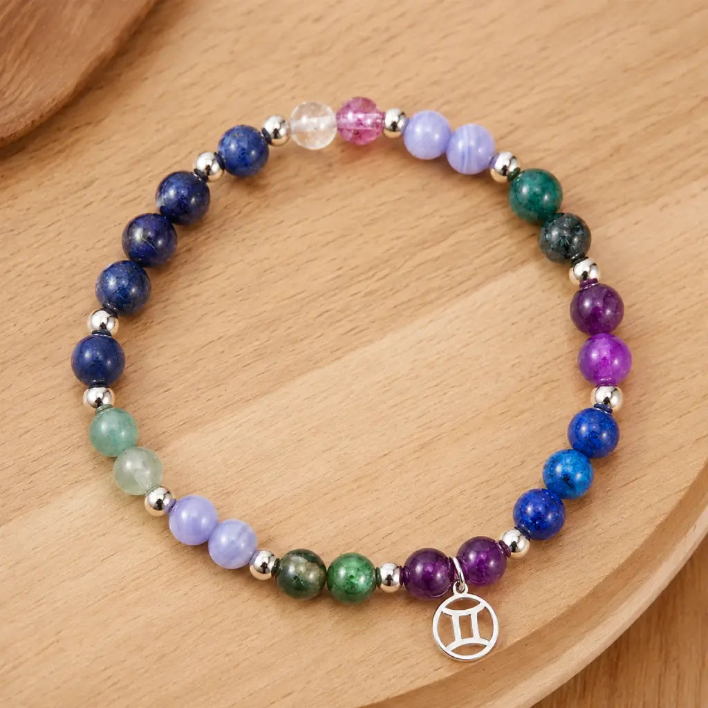 Gemini zodiac handmade bracelet with colorful healing crystals on wood. New 2026 birthstone jewelry design. Celebrate your Gemini traits with this unique piece.