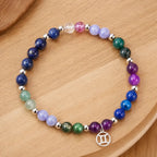 Gemini zodiac handmade bracelet with colorful healing crystals on wood. New 2026 birthstone jewelry design. Celebrate your Gemini traits with this unique piece.