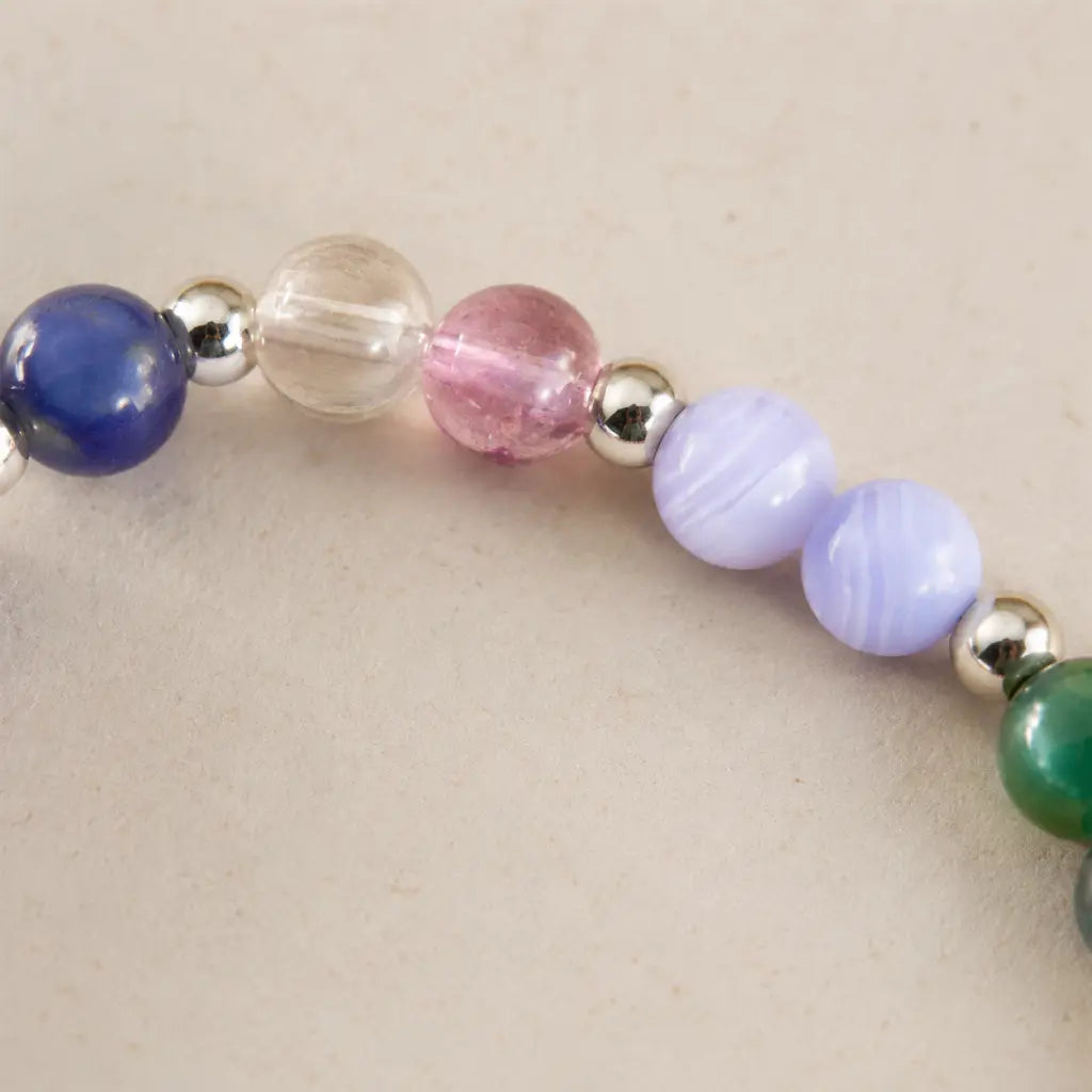 Multicolored beaded gemini zodiac bracelet on a beige background