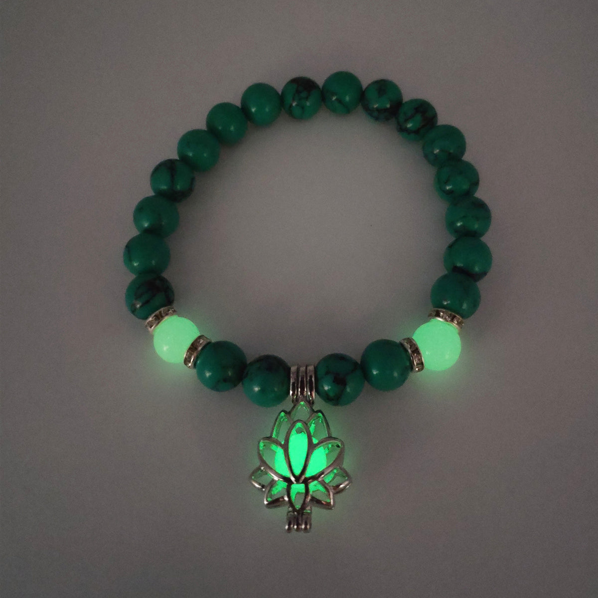 Glow in the dark lotus bracelet green stone beads with a green glow view, with 8 mm real-stone beads, elastic fit, a silver-color lotus, and light-charged accents shown after dark.