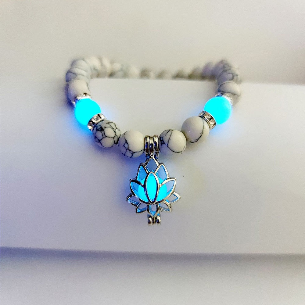 Glow in the dark lotus bracelet pale marbled beads with a blue glow view, with 8 mm real-stone beads, elastic fit, a silver-color lotus, and light-charged accents shown after dark.