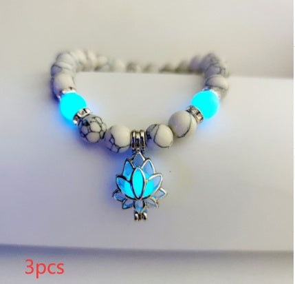 Glow in the dark lotus bracelet three-piece pale marbled set with blue glow, with 8 mm real-stone beads, elastic fit, a silver-color lotus, and light-charged accents in a dim room.